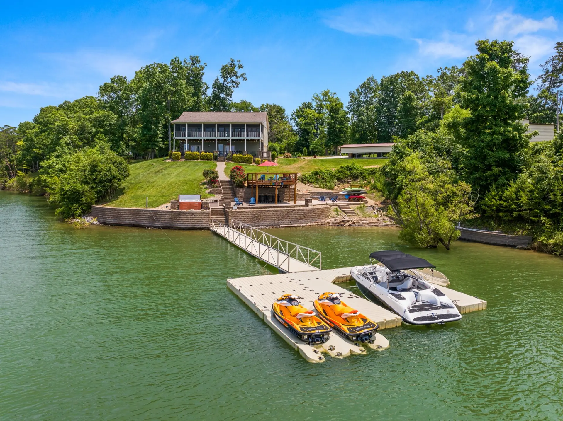 Aerial view of the floating dock with a boat in the slip and two jet skis on their ports