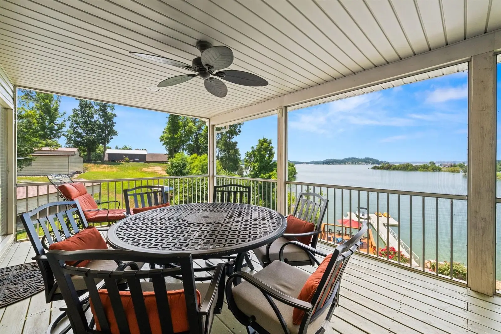 The screened porch set for dinner, table for six with the lake beyond the screens
