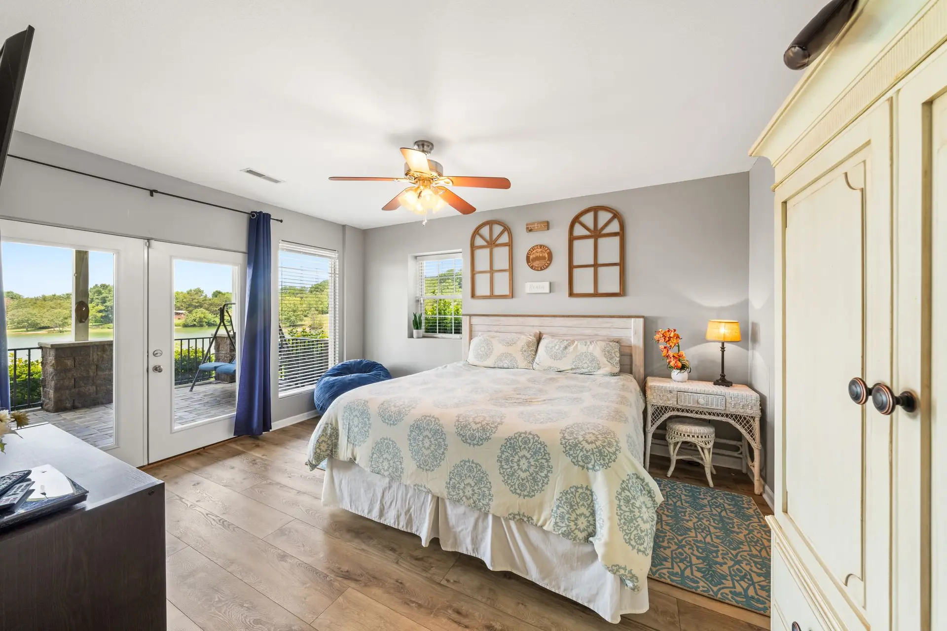 Lower-level bedroom 3 with king bed, teal quilt and doors to the patio