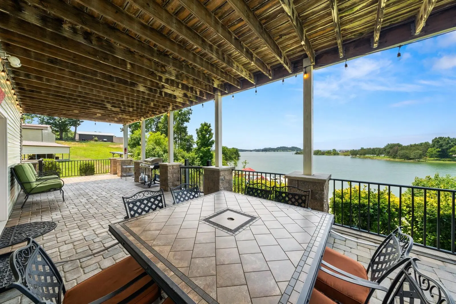 Covered patio dining with Douglas Lake beyond on a summer day