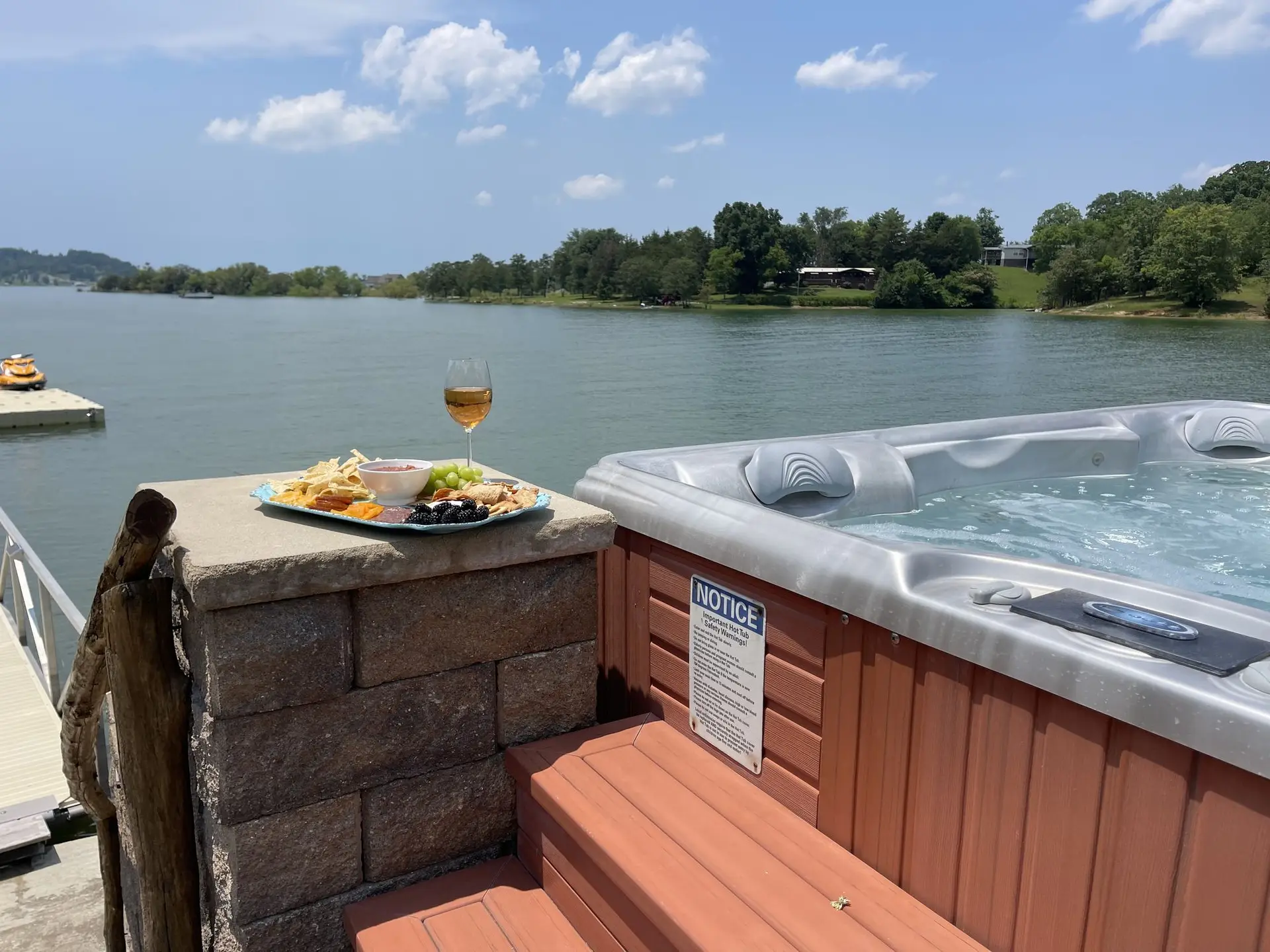 Charcuterie and wine beside the hot tub with Douglas Lake beyond