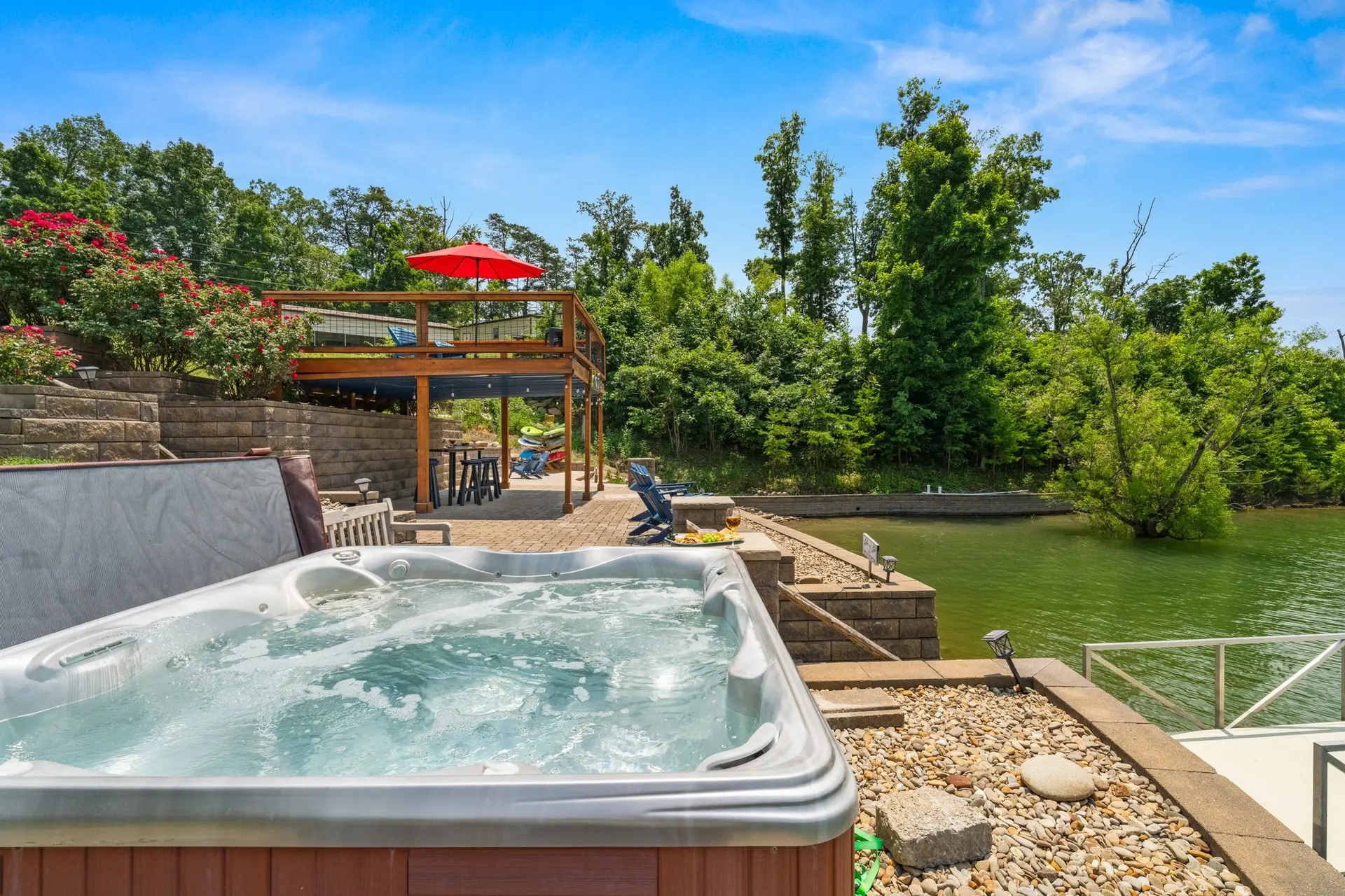 Hot tub with the red-umbrella sundeck, pavilion and lake in the background