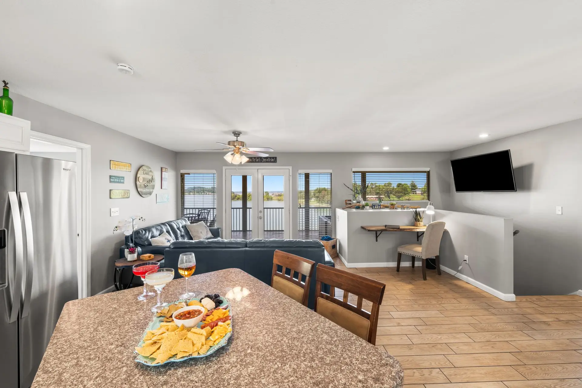 Kitchen island with chips, salsa and wine looking through the open great room to the lake