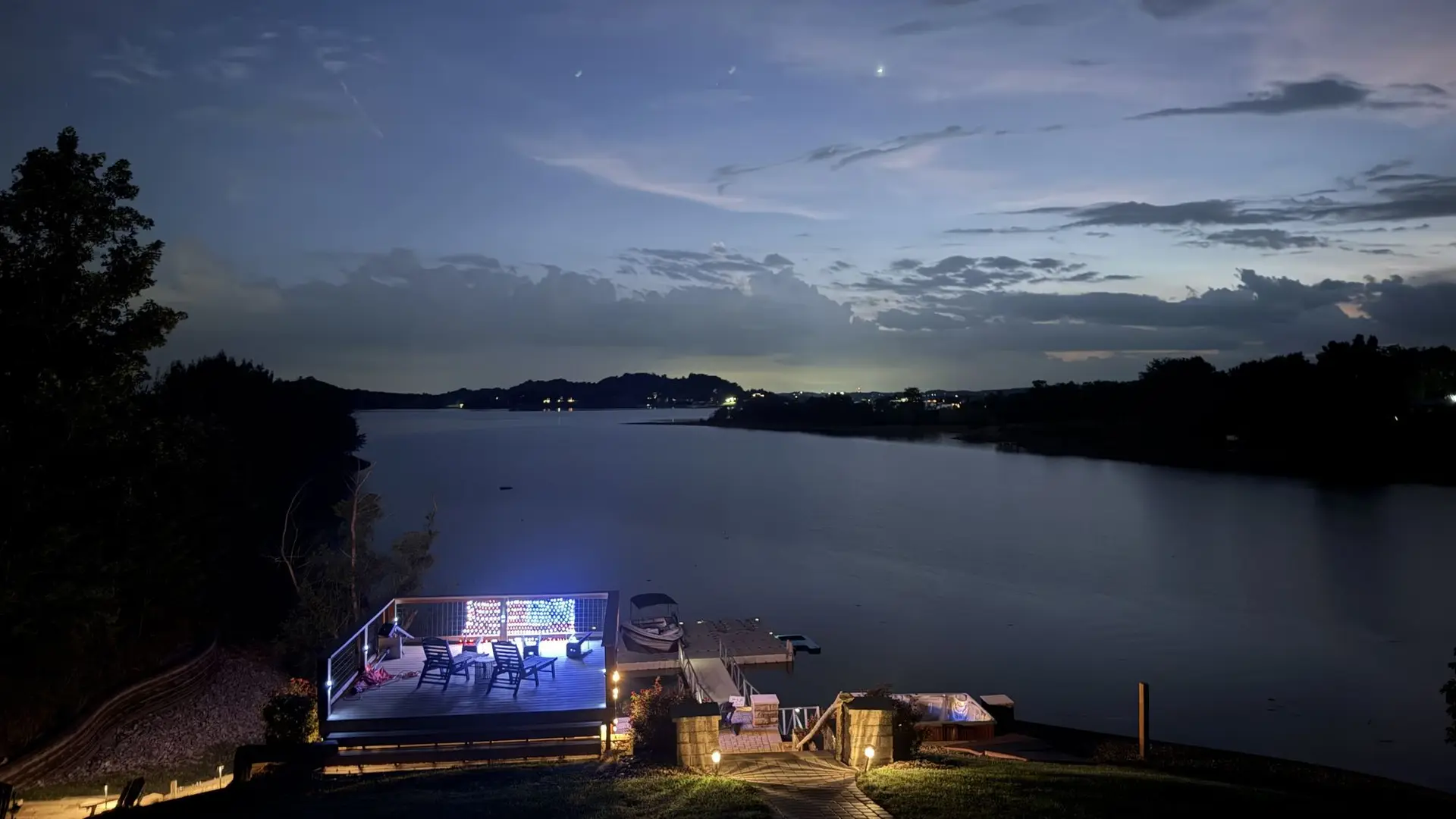 The pavilion at night with the outdoor TV glowing over the lake