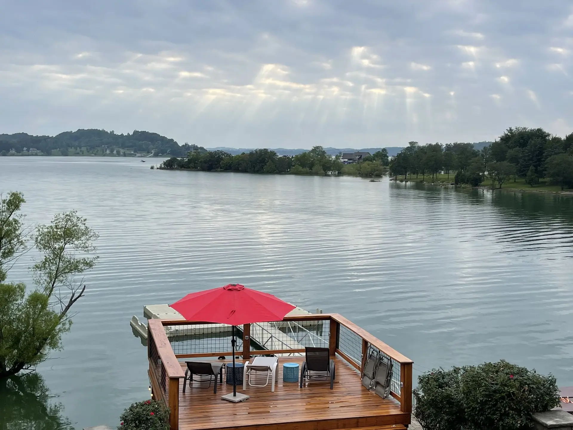Sun rays breaking through clouds over Douglas Lake above the red-umbrella sundeck
