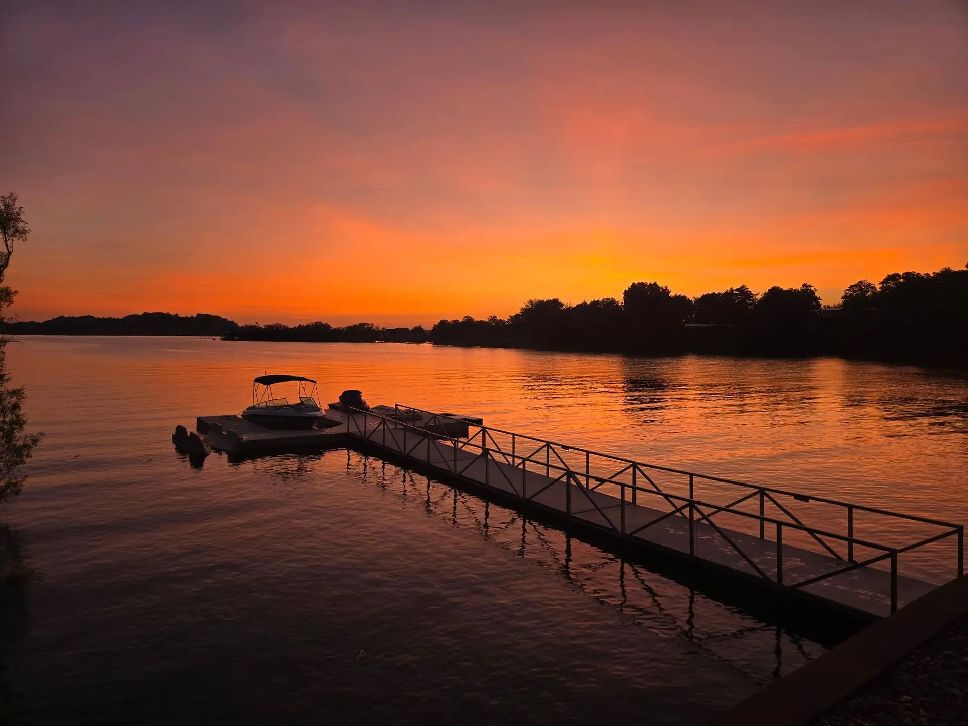 Fiery orange sunset over the floating dock and pontoon boat