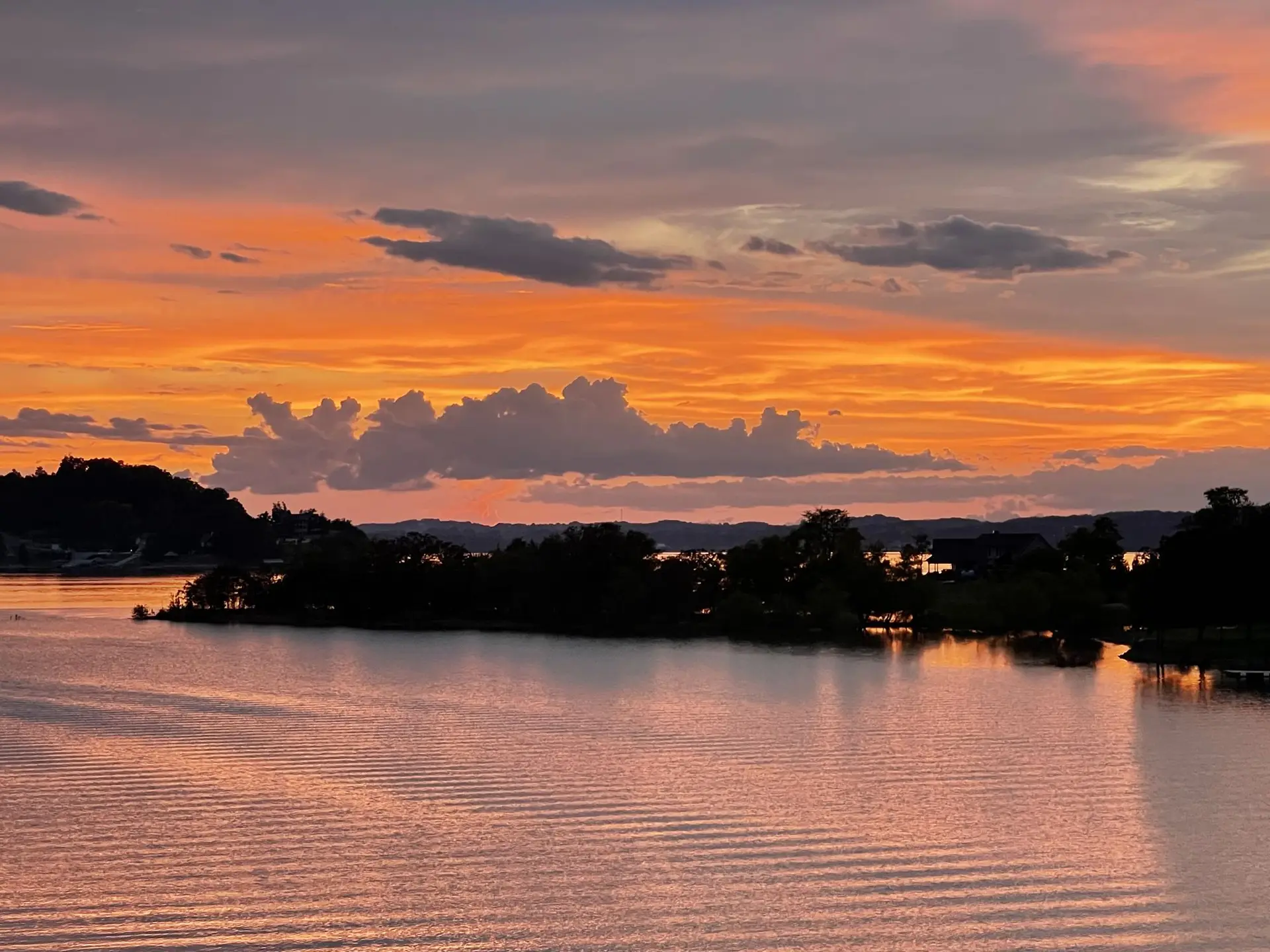Orange sunset clouds mirrored on Douglas Lake